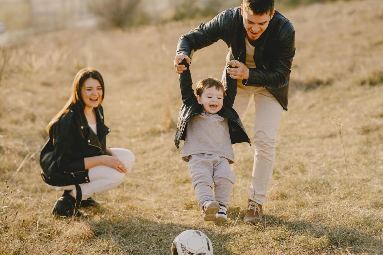 A family of 3 playing soccer.