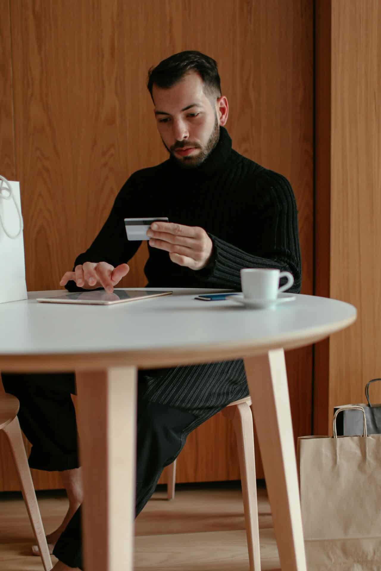 A man sitting at a table on his tablet.
