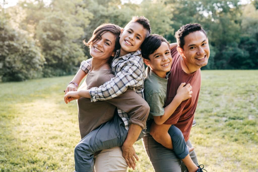 A family of 4 posing and smiling for the camera.