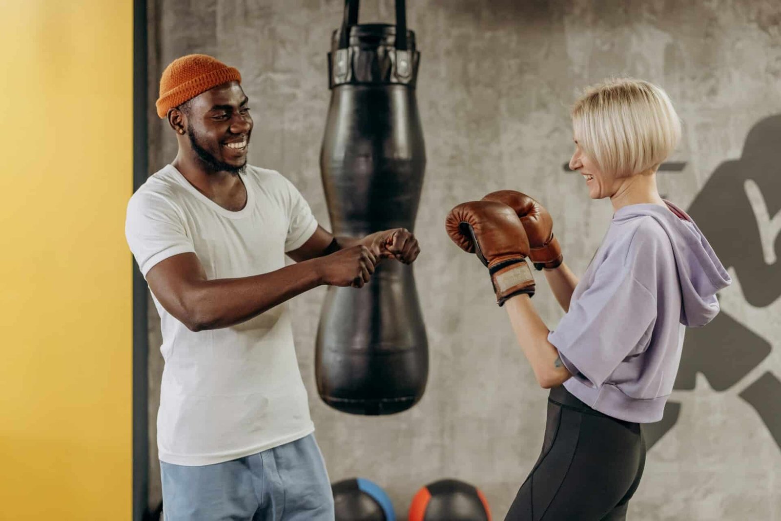 A man coaching a woman on how to box.