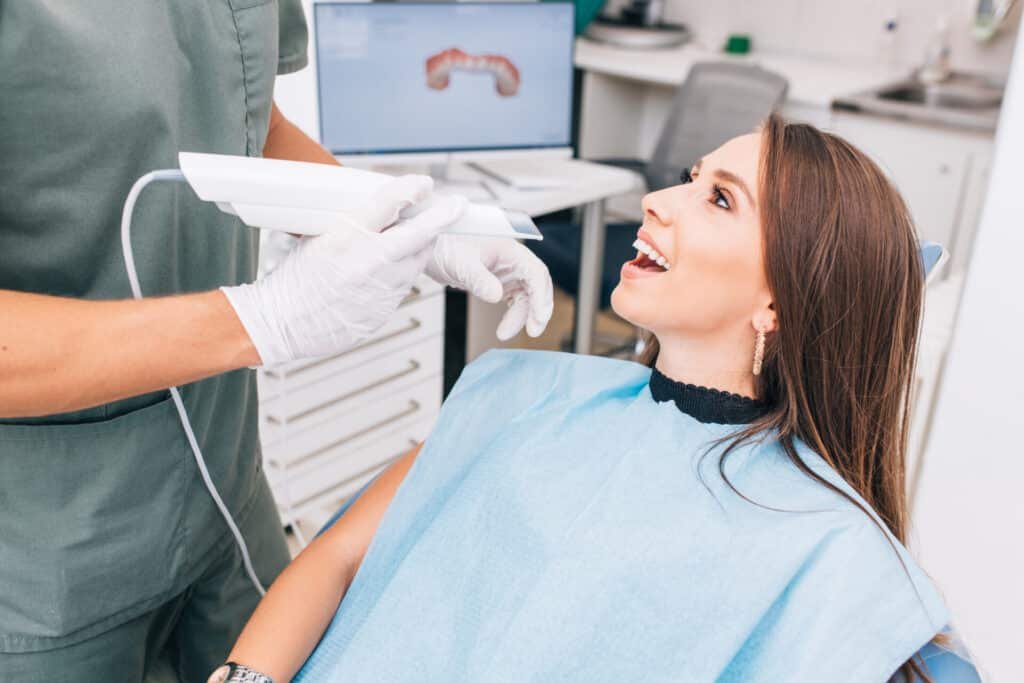 A smiling patient opening her mouth for the Dentist to start working.